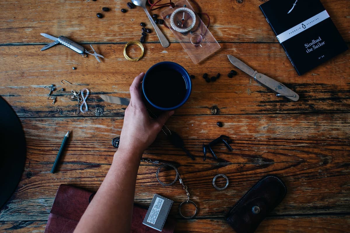 Everyday carry items including a small flashlight on a wooden surface