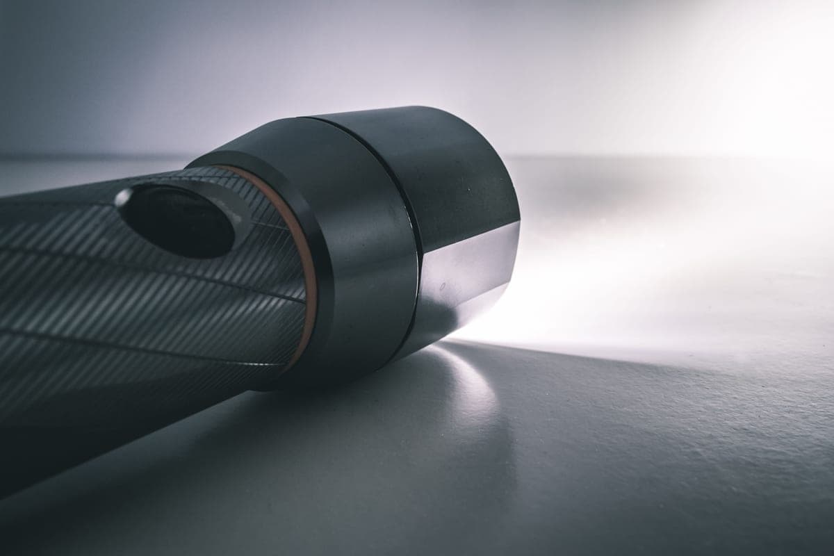 A metal flashlight body against a dark background